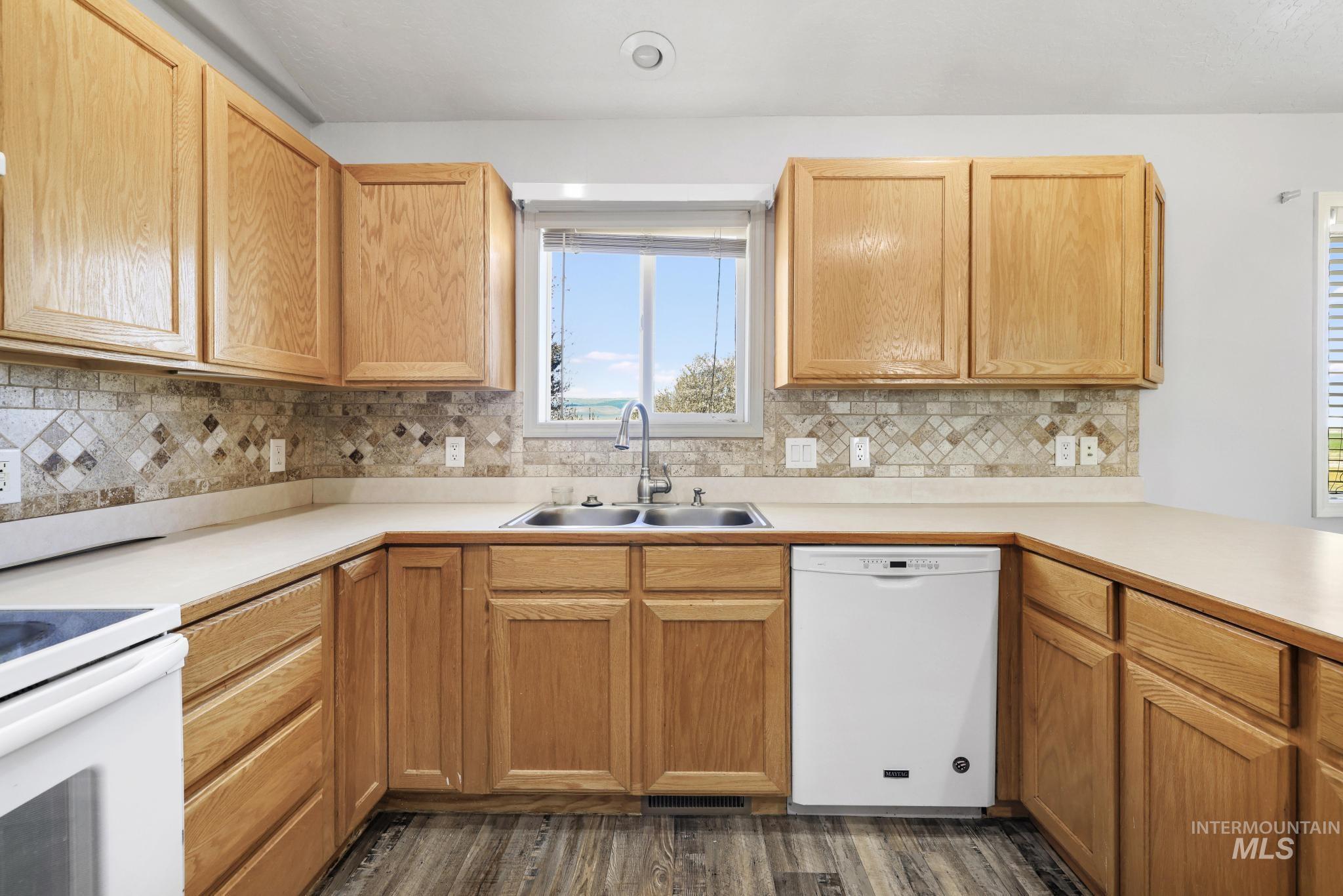 445 South College Street Oakley, ID 83346 - Photo 6 of 24 Kitchen with light countertops, white appliances, dark wood-style flooring, and light wood finish cabinets
