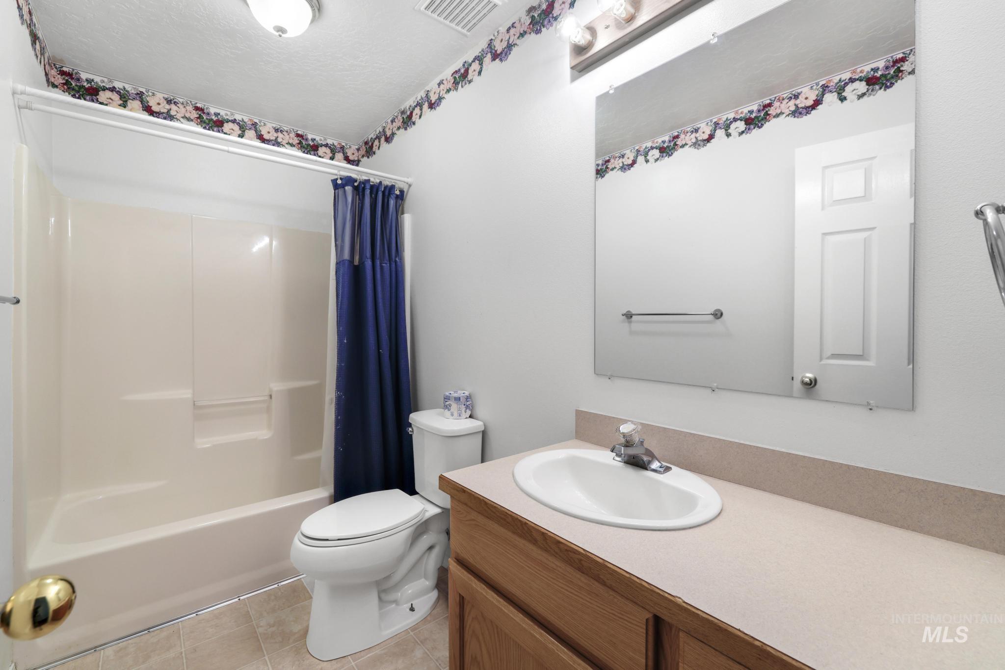 445 South College Street Oakley, ID 83346 - Photo 9 of 24 Full bathroom featuring vanity, shower / bath combo, light tile patterned floors, and a textured ceiling