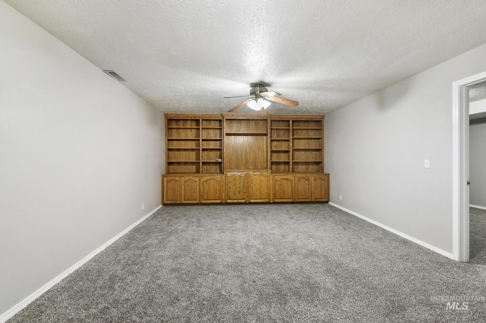 445 South College Street Oakley, ID 83346 - Photo 10 of 24 Spare room with a textured ceiling, carpet, and a ceiling fan