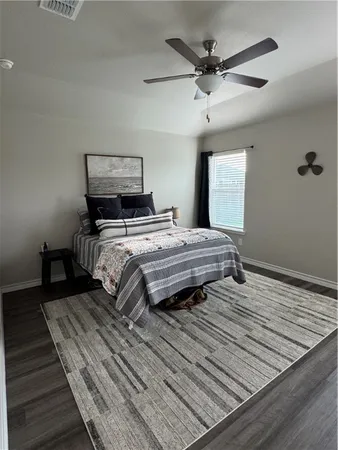a bedroom with bed and wooden floor