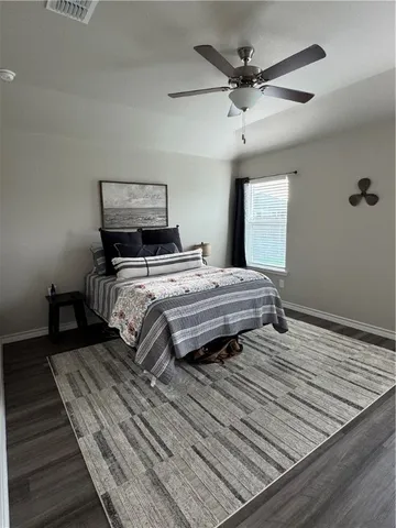 a bedroom with bed and wooden floor