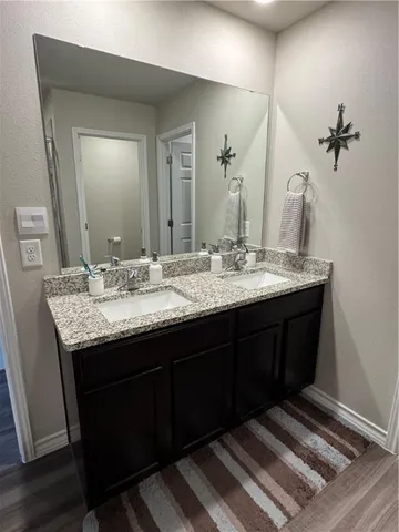 a bathroom with a granite countertop sink a toilet and a mirror