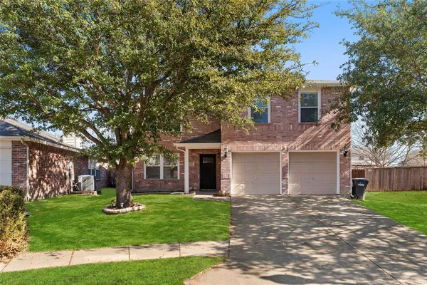 a front view of a house with a garden and trees