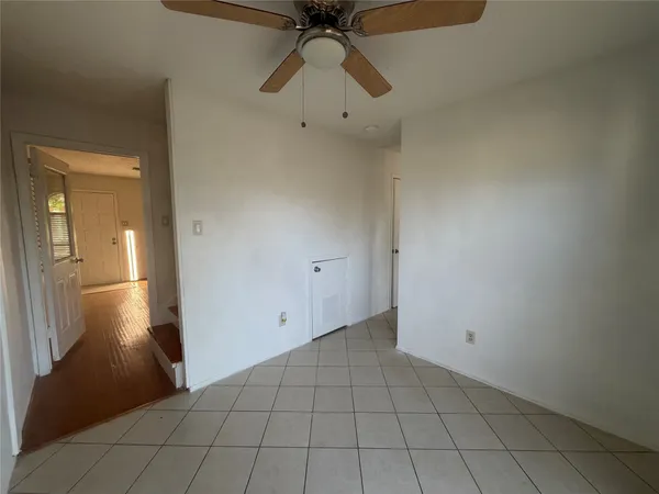 a view of an empty room and chandelier fan