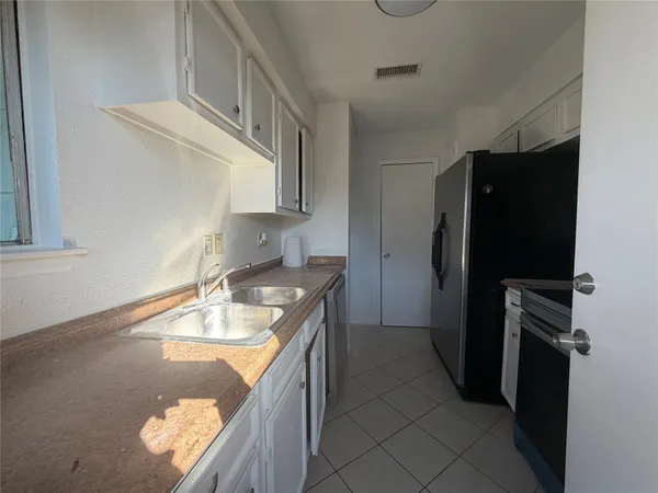 a kitchen with a refrigerator and a sink