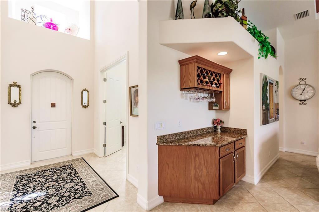 7684 Cottesmore Drive Naples, FL 34113 - Photo 21 of 46 a kitchen with stainless steel appliances granite countertop a refrigerator and a stove