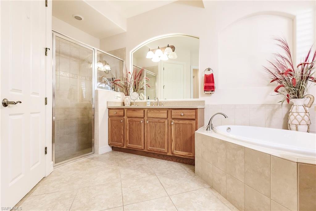 7684 Cottesmore Drive Naples, FL 34113 - Photo 33 of 46 a spacious bathroom with a bathtub sink and mirror