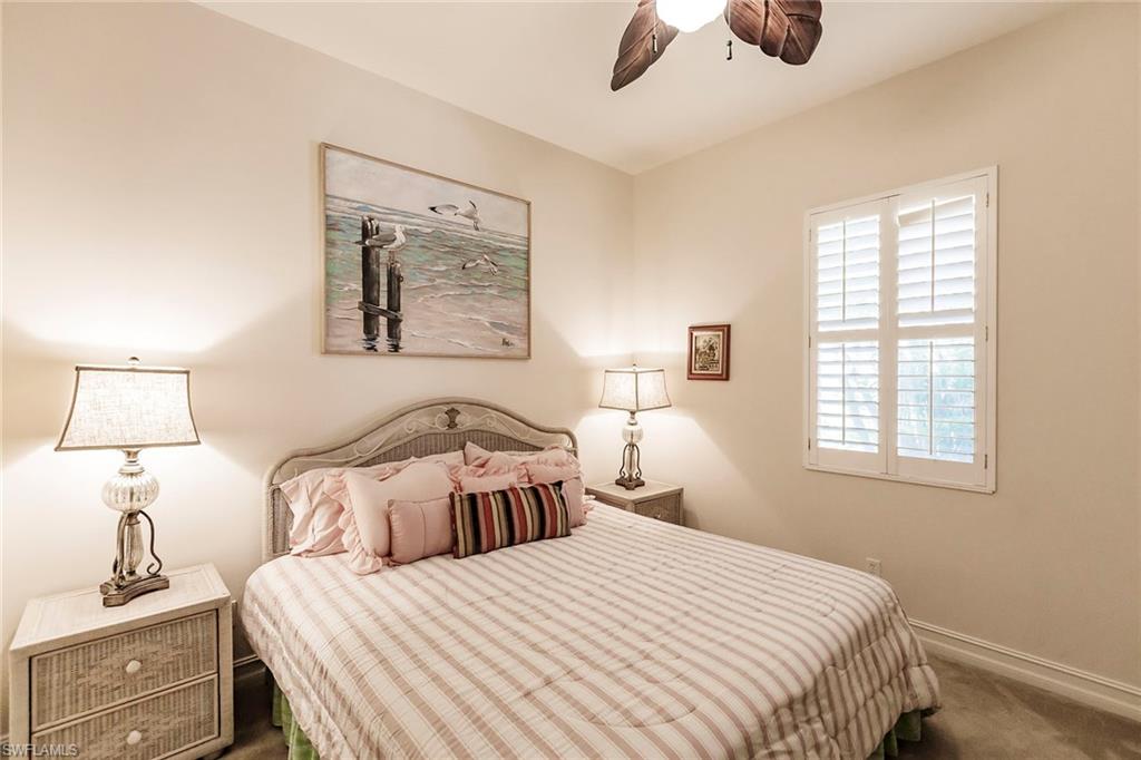 7684 Cottesmore Drive Naples, FL 34113 - Photo 34 of 46 a bedroom with a bed and a lamp