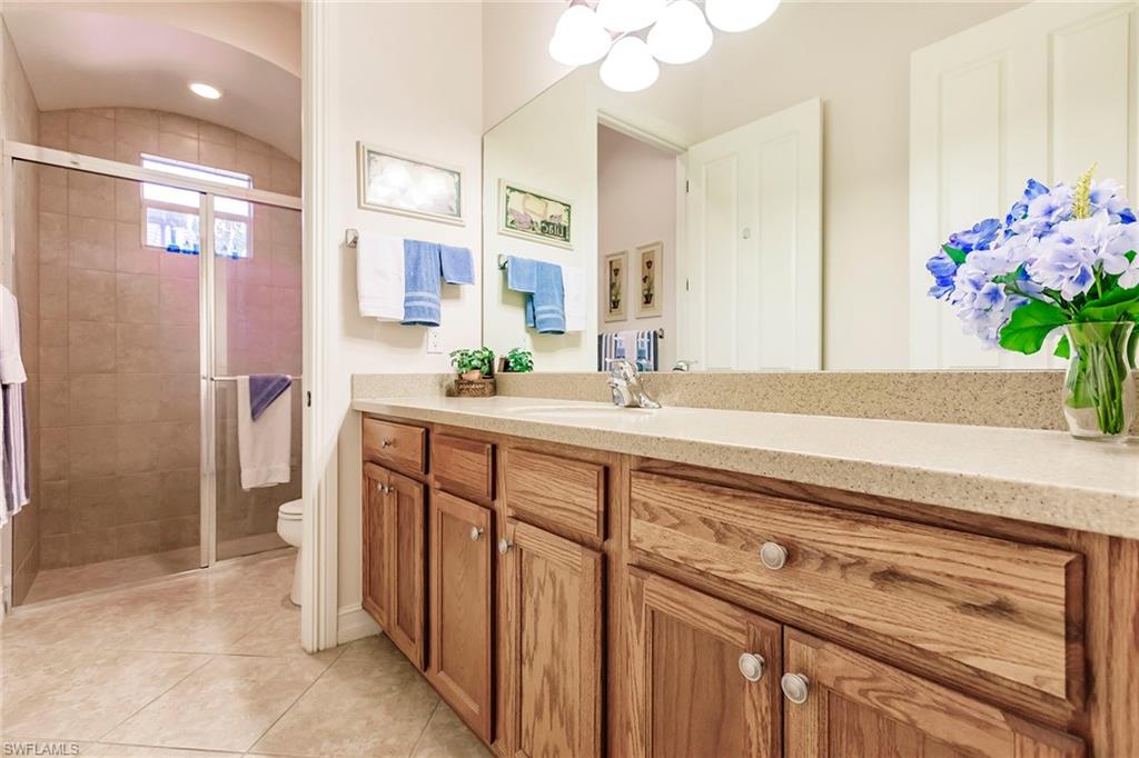 7684 Cottesmore Drive Naples, FL 34113 - Photo 37 of 46 a bathroom with a sink a vanity and a mirror