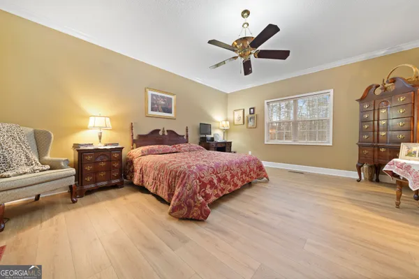 a spacious bedroom with a bed and wooden floor