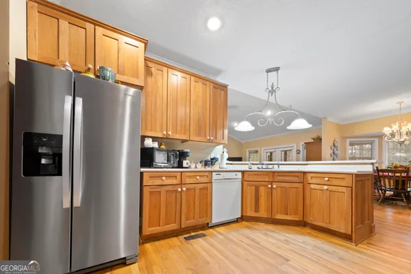 a kitchen with stainless steel appliances granite countertop a refrigerator a sink dishwasher a stove and a refrigerator