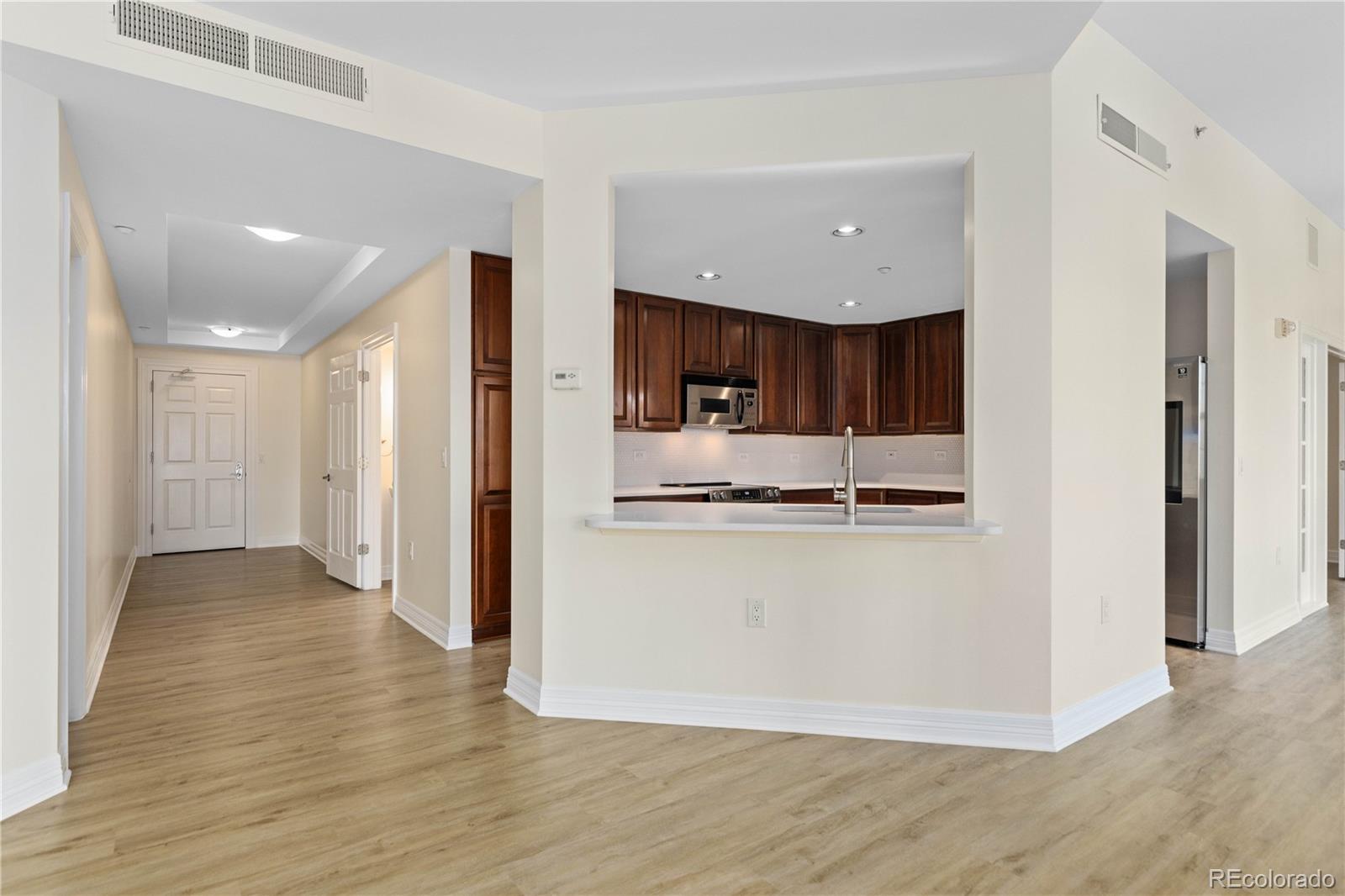 475 West 12th Avenue, Unit 6G Denver, CO 80204 - Photo 7 of 44 a view of kitchen with kitchen island granite countertop wooden floor and refrigerator