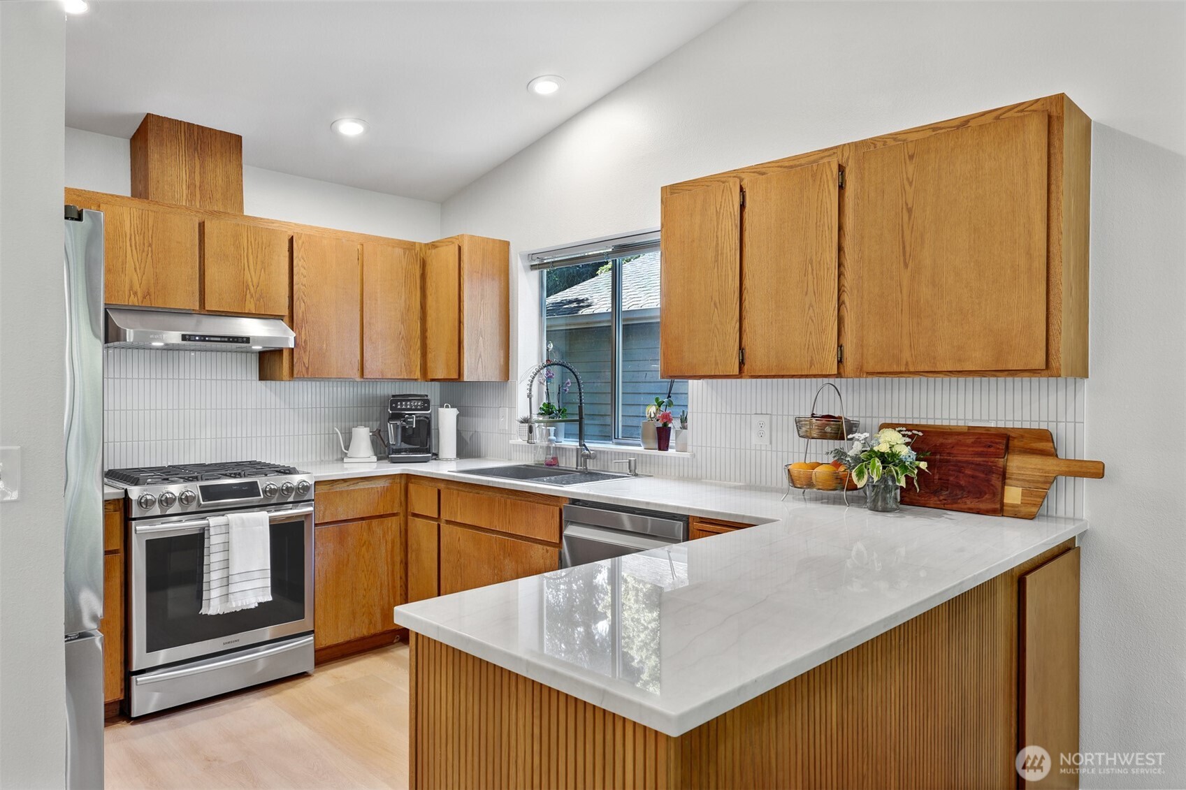5126 South Garden Loop Road, Unit 11 Seattle, WA 98118 - Photo 12 of 36 a kitchen with stainless steel appliances granite countertop a sink stove and cabinets