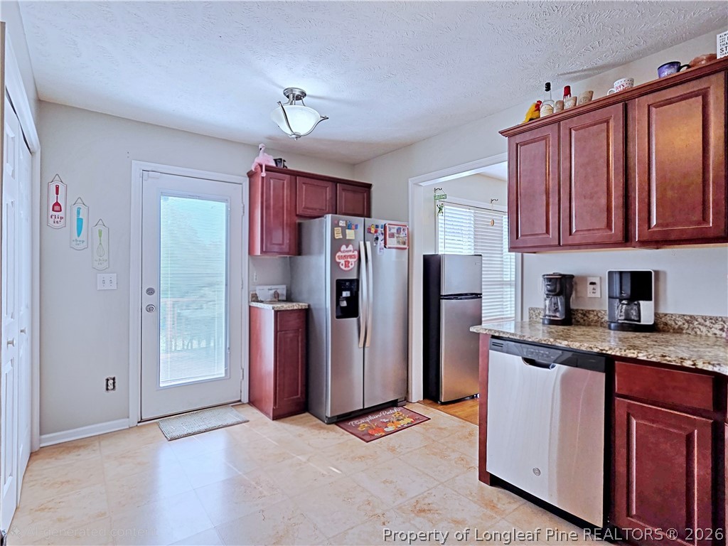 5218 Pringle Way Hope Mills, NC 28348 - Photo 14 of 43 a kitchen with stainless steel appliances granite countertop a refrigerator and a sink