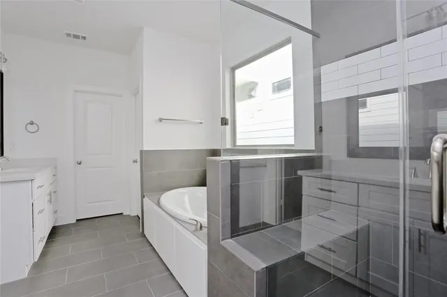 a bathroom with a bathtub sink and mirror