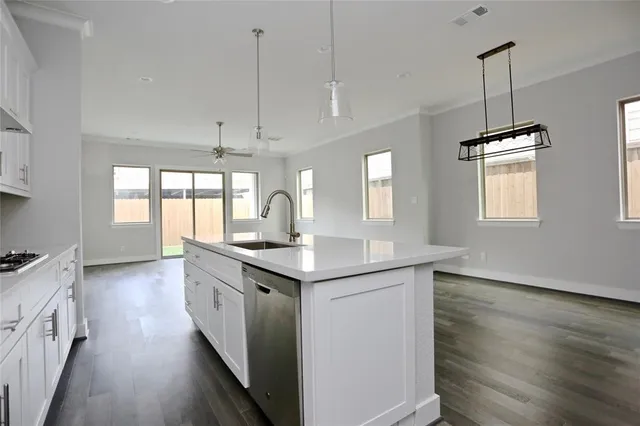 a kitchen with a sink stove and wooden floor