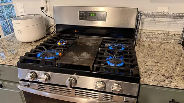 a kitchen with granite countertop a sink appliances and cabinets