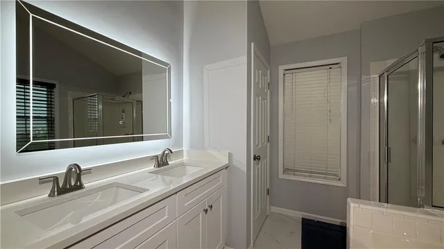 a bathroom with a granite countertop sink mirror bathtub and shower