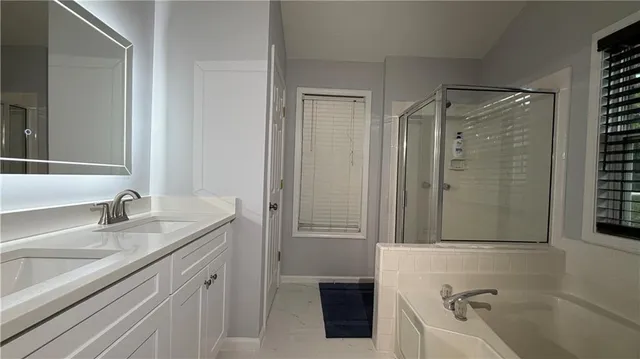 a bathroom with a granite countertop tub sink and mirror