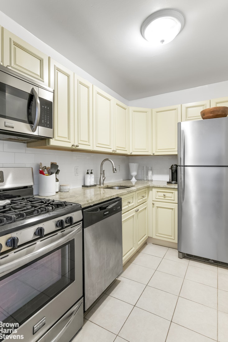 340 East 74th Street, Unit 11A Manhattan, NY 10021 - Photo 3 of 9 a kitchen with a stove top oven sink and cabinets