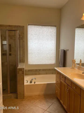 a bathroom with a granite countertop sink and a bathtub