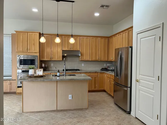 a kitchen with a sink a counter space appliances and cabinets