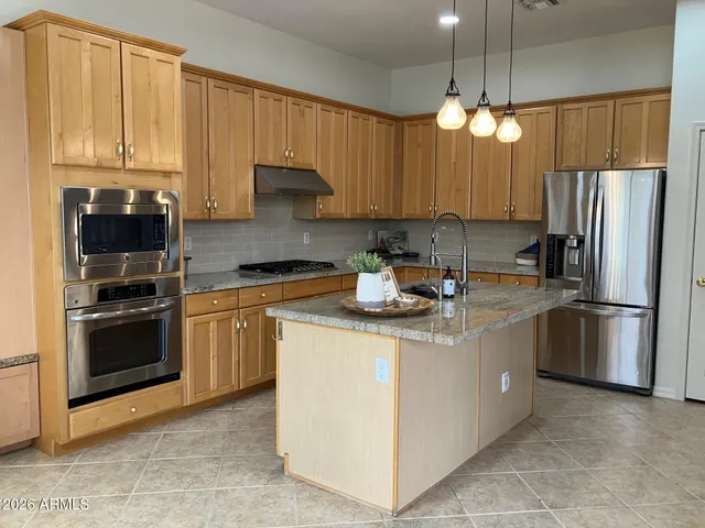 a kitchen with stainless steel appliances granite countertop a refrigerator a stove a sink and a refrigerator