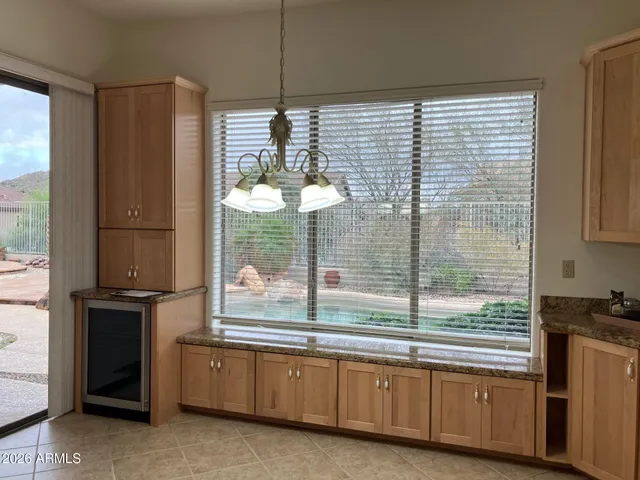 a kitchen with stainless steel appliances wooden floor and a large window