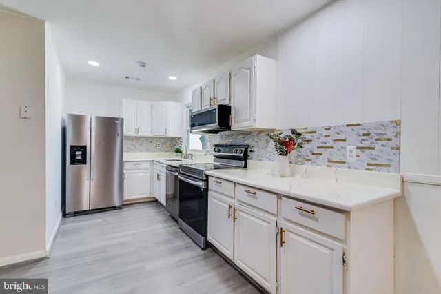 a kitchen with stainless steel appliances a refrigerator and a stove top oven