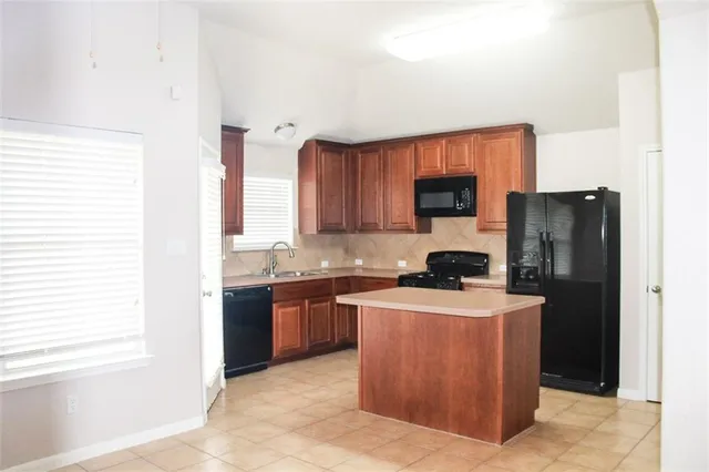 a kitchen with stainless steel appliances granite countertop a stove a sink a refrigerator and a microwave