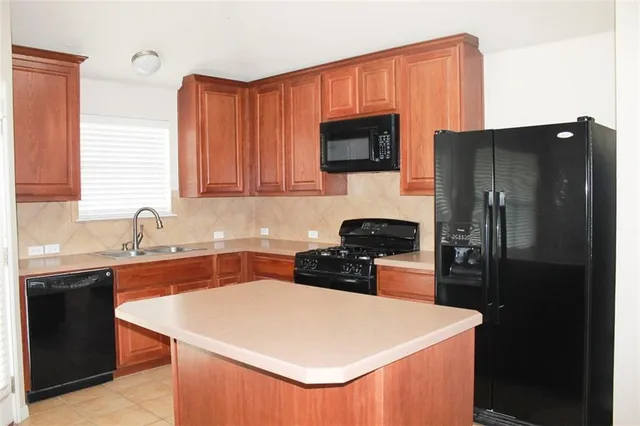 a kitchen with a sink a stove a refrigerator and a microwave