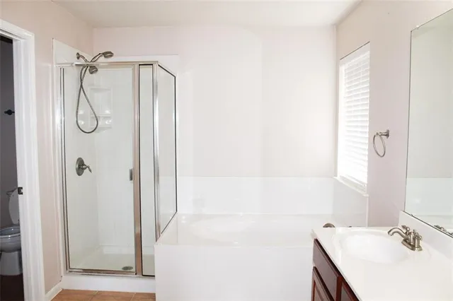 a bathroom with a granite countertop shower sink vanity and a mirror