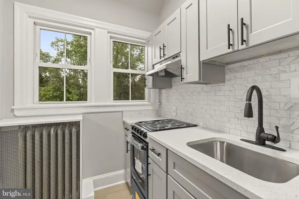 a kitchen with stainless steel appliances a sink a stove and a window