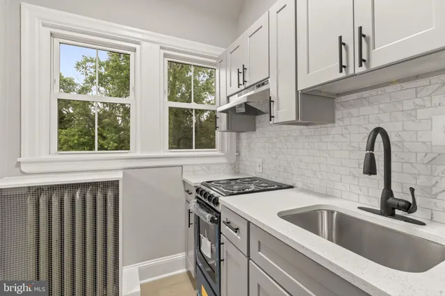 a kitchen with stainless steel appliances a sink a stove and a window