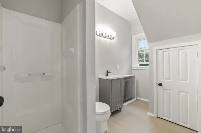a bathroom with a granite countertop toilet and a sink