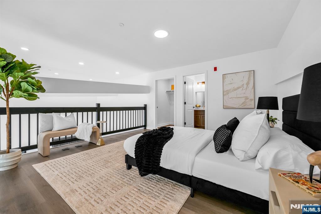 315 Railroad Avenue, Unit 114 East Rutherford, NJ 07073 - Photo 16 of 28 a bedroom with a bed a couch and a potted plant on the dresser