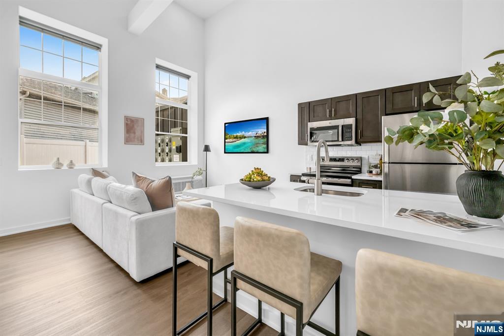 315 Railroad Avenue, Unit 114 East Rutherford, NJ 07073 - Photo 4 of 28 a living room with furniture a flat screen tv and a potted plant
