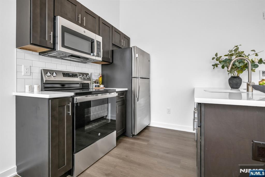 315 Railroad Avenue, Unit 114 East Rutherford, NJ 07073 - Photo 8 of 28 a kitchen with stainless steel appliances a stove a microwave and a sink