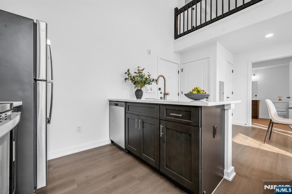 315 Railroad Avenue, Unit 114 East Rutherford, NJ 07073 - Photo 10 of 28 a kitchen with stainless steel appliances a sink a refrigerator and a wooden floor