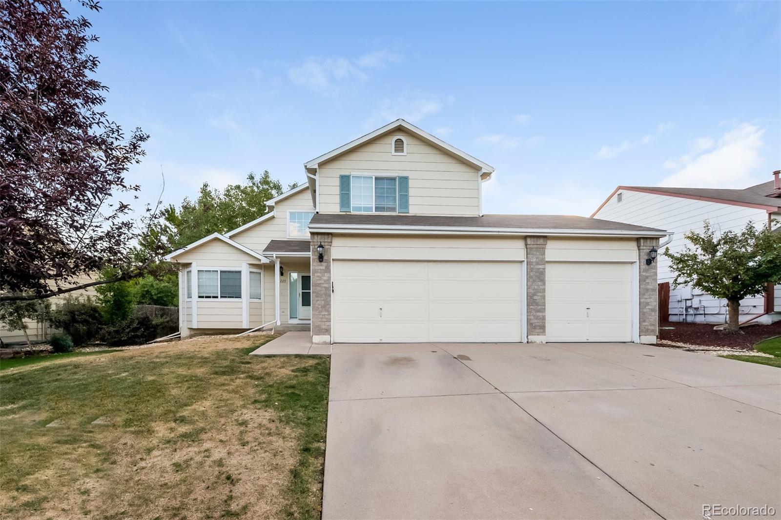 a view of house with garage and a yard