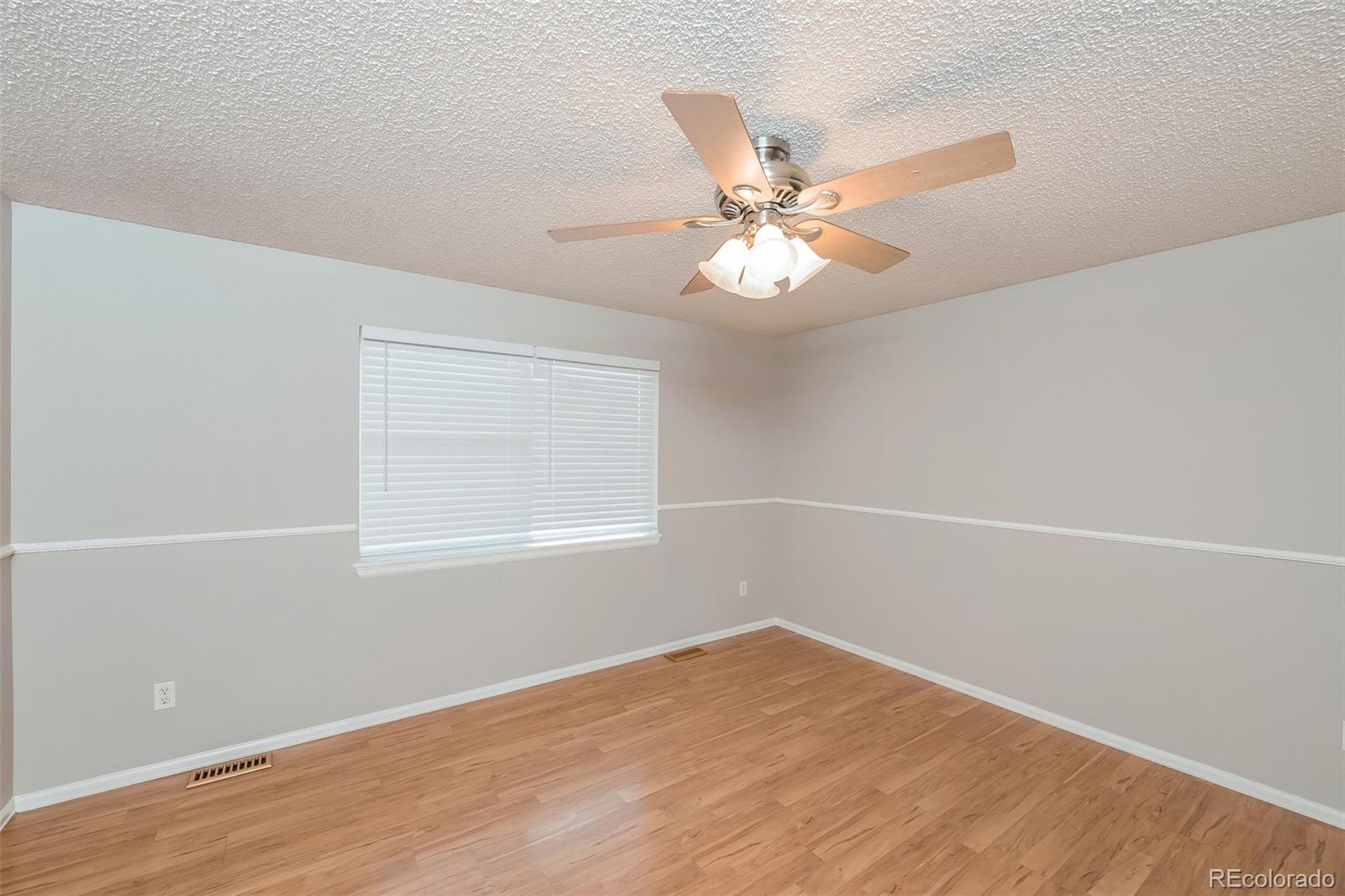 2229 South Truckee Street Aurora, CO 80013 - Photo 5 of 18 an empty room with a window and a fan