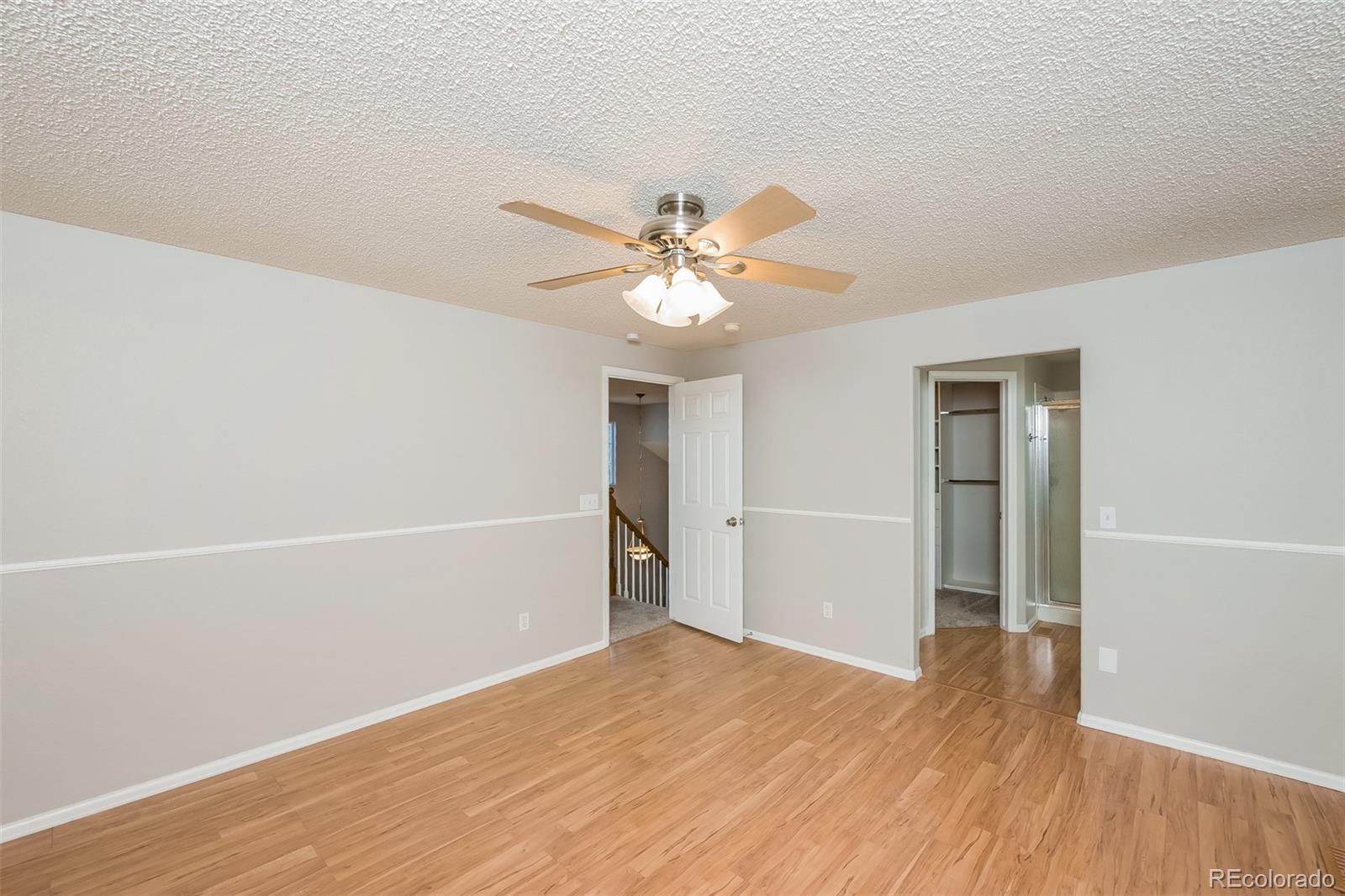 2229 South Truckee Street Aurora, CO 80013 - Photo 6 of 18 an empty room with wooden floor and a ceiling fan