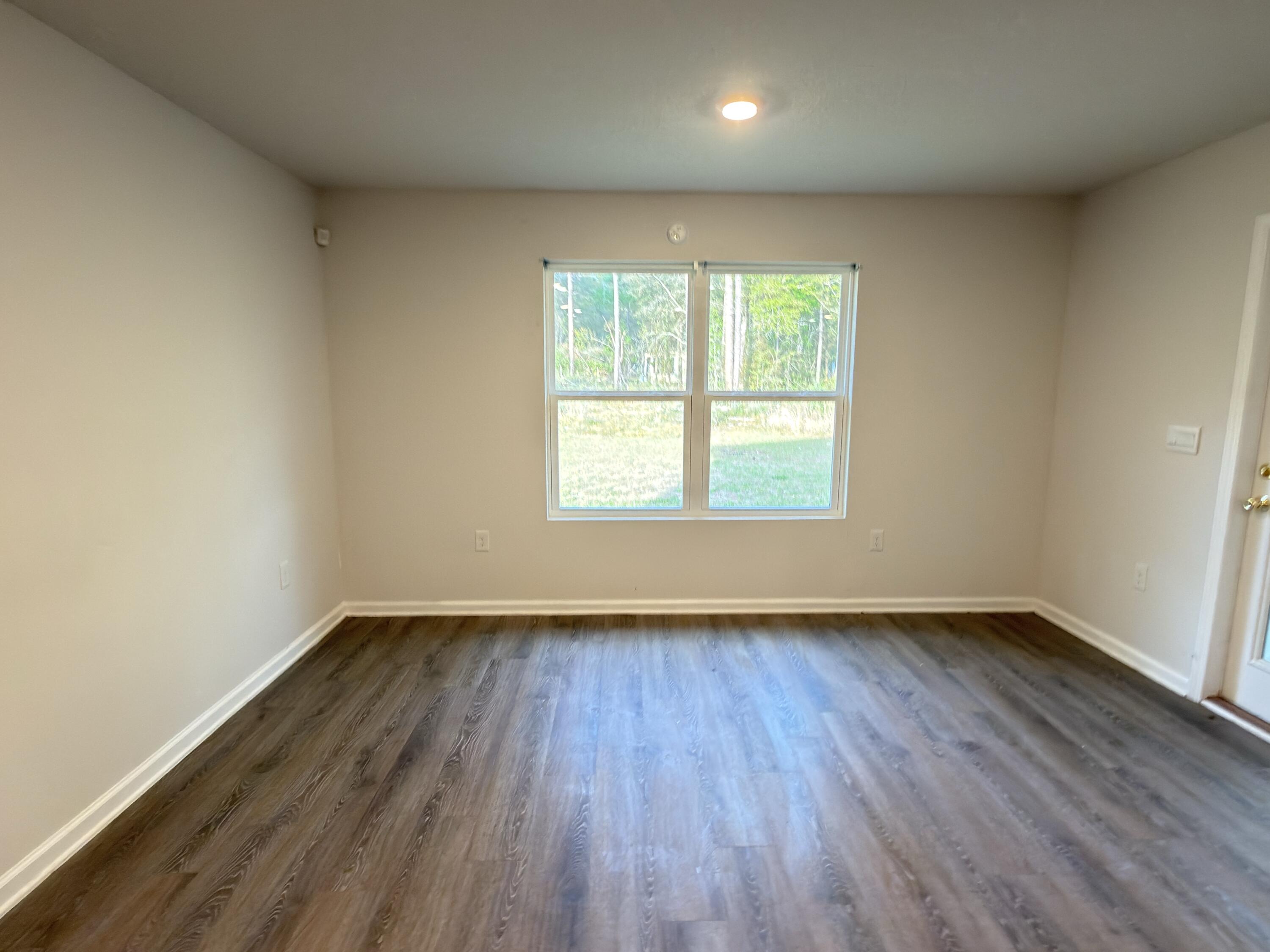 3545 Sugar Maple Lane Crestview, FL 32539 - Photo 8 of 27 an empty room with wooden floor and windows