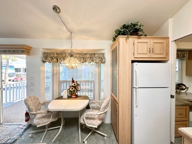 a dining room with furniture a chandelier and window