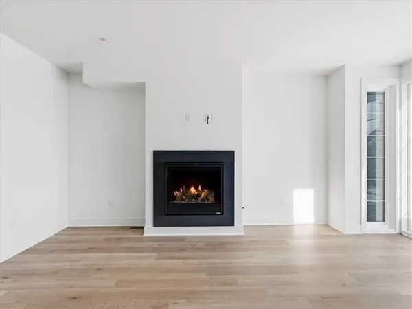 a view of an empty room with a fireplace and a window