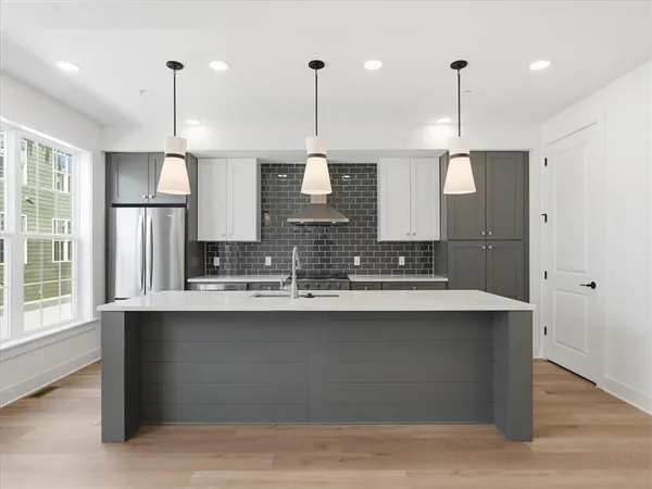 a kitchen with stainless steel appliances granite countertop a sink a stove a refrigerator and island