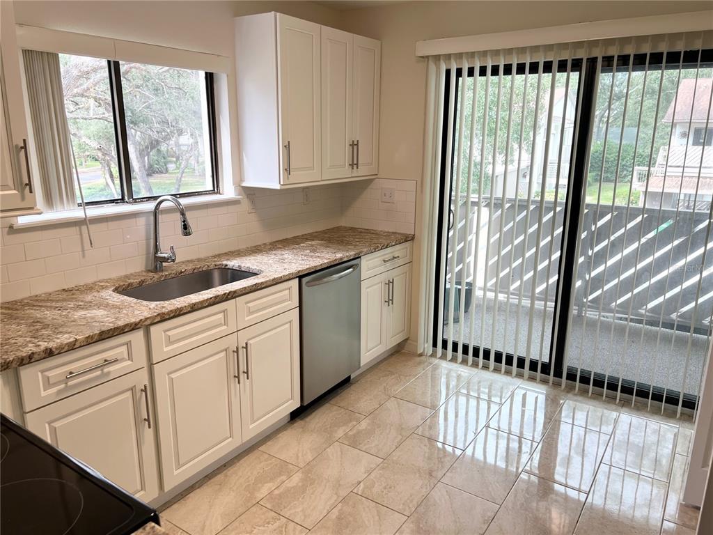510 Mistletoe Court, Unit D Safety Harbor, FL 34695 - Photo 5 of 18 a kitchen with a sink window and cabinets