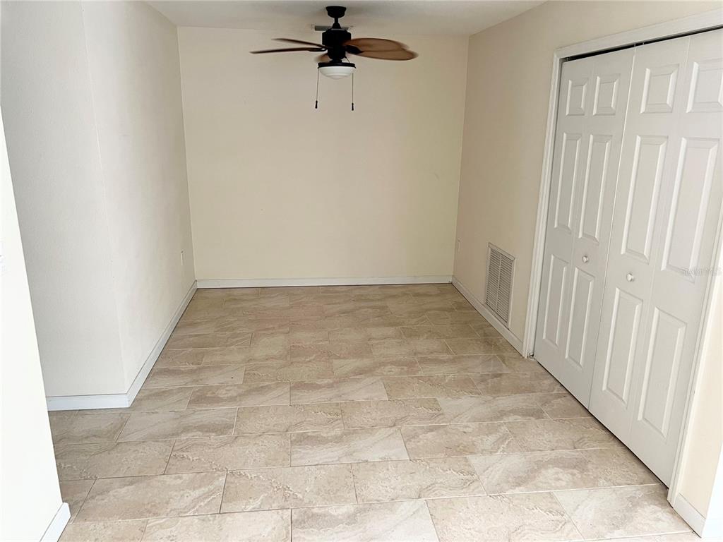 510 Mistletoe Court, Unit D Safety Harbor, FL 34695 - Photo 7 of 18 an empty room with a chandelier fan and hallway