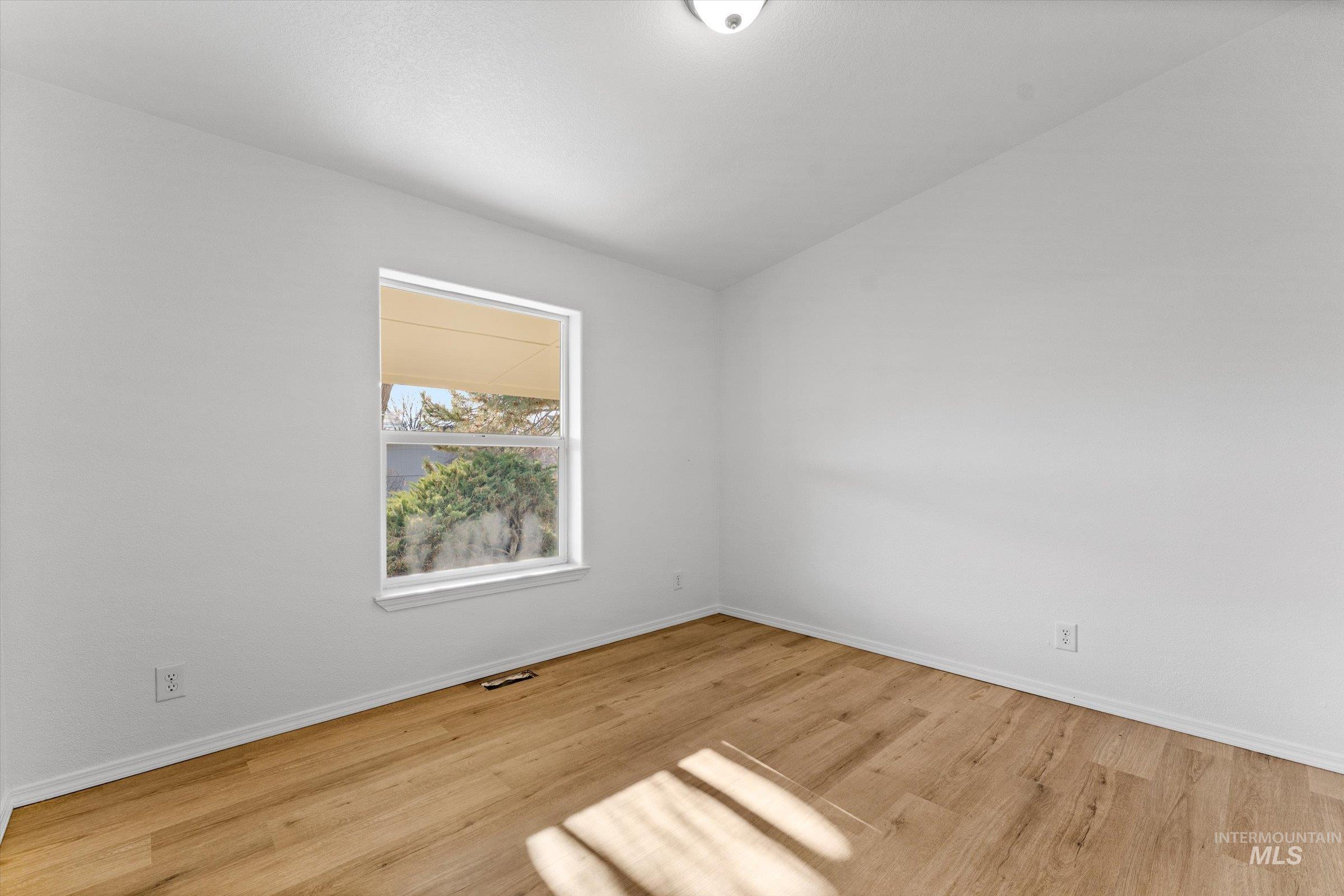 421 South Curtis Road, Unit 122 122 Boise, ID 83705 - Photo 14 of 24 Empty room with vaulted ceiling and light wood-style floors