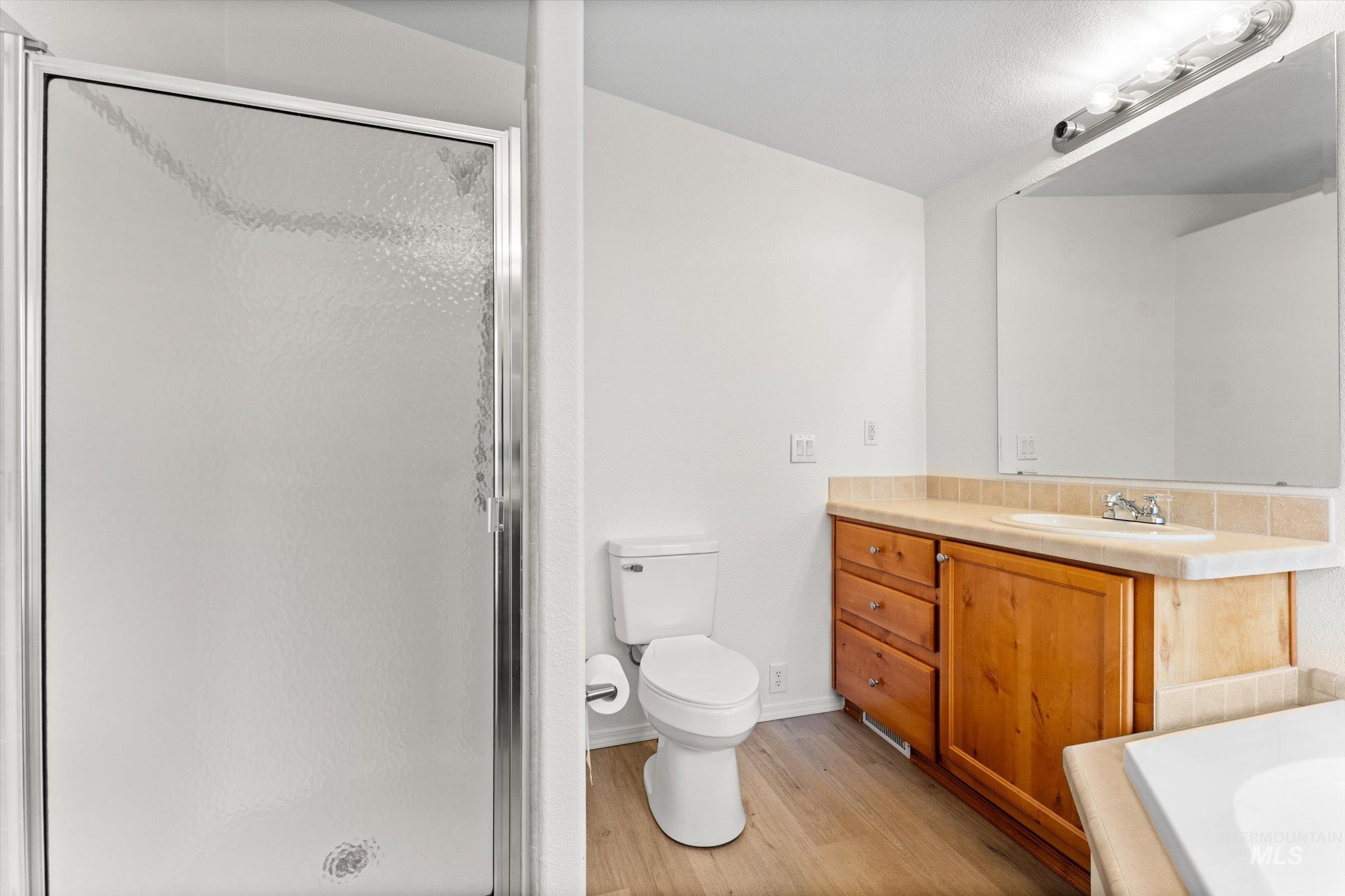 421 South Curtis Road, Unit 122 122 Boise, ID 83705 - Photo 18 of 24 Full bath featuring light wood-style flooring, vanity, and a stall shower